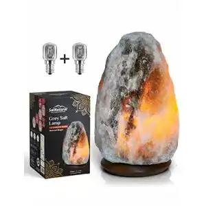 Salzlampe aus reinem Bergkristallsalz auf Holzsockel mit Glühbirnen
