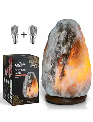 Salzlampe aus reinem Bergkristallsalz auf Holzsockel mit Glühbirnen
