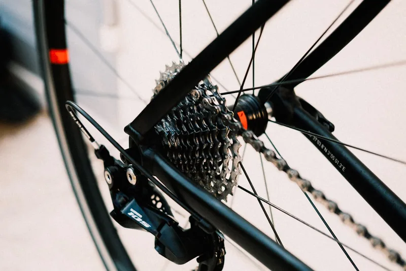 Eine Hand montiert eine 10-fach-Kassette auf eine Fahrradnabe, im Kontext der Fahrradwartung.