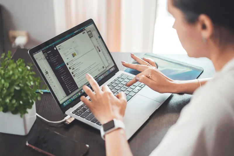 Eine Person tippt an einem 15-Zoll-Laptop, der auf einem Schreibtisch steht, ideal für Arbeit.