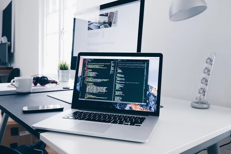 Ein aufgeräumter Home-Office-Schreibtisch mit einem 15-Zoll-Laptop als zentralem Element.
