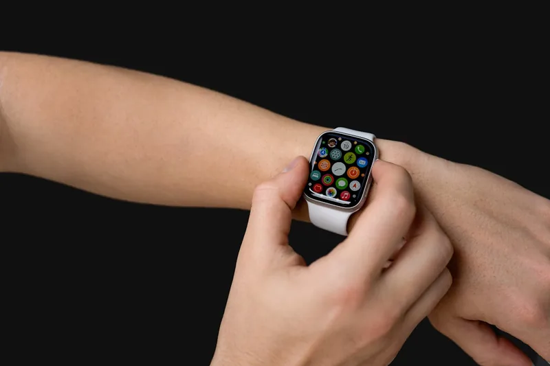 Eine moderne Smartwatch liegt auf einem Schreibtisch neben einem Laptop, symbolisiert Produktivität im Homeoffice.