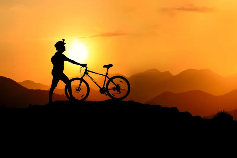 Malerische Fahrradtour durch Berglandschaft bei Sonnenuntergang, symbolisiert Freiheit und Ausdauer beim Radsport.