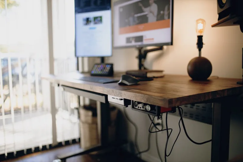 Aufgeräumter Schreibtisch im Home-Office mit Laptop. Kabelmanagement mit 3-fach Steckdosenleiste.