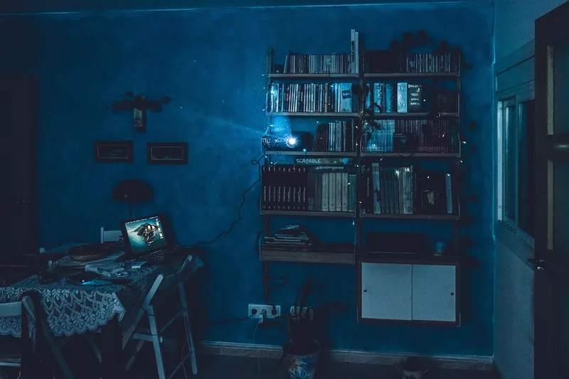 Ein gemütlicher, modern eingerichteter Heimkinoraum mit einer großen 3D-Projektionsleinwand und gedämpftem Licht.