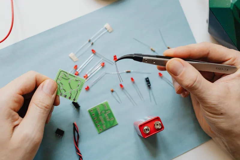 Hand, die eine 9V Lithium-Batterie in ein Rauchmelder-Gerät einsetzt.