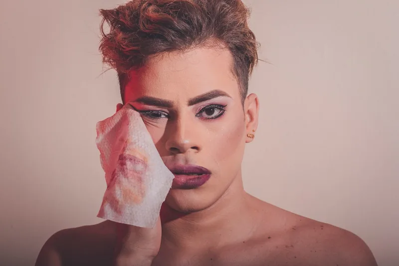 Eine Person entfernt sanft Make-up von der Wange mit einem Abschminktuch in der Hand.
