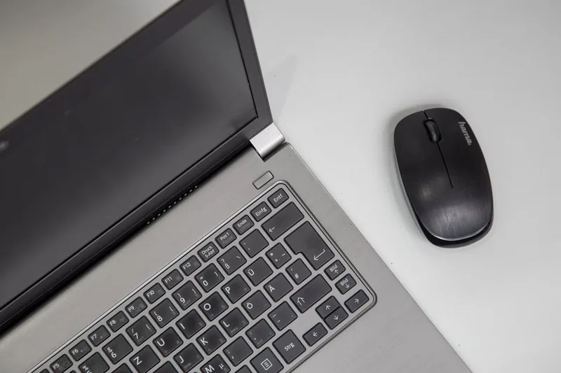 Ein schlankes Laptop-Modell, geöffnet auf einem schlichten Hintergrund, präsentiert als Produktfoto.