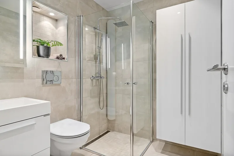 Ein stilvolles, modernes Badezimmer mit einer begehbaren Dusche und integrierter Acryl-Duschwanne.