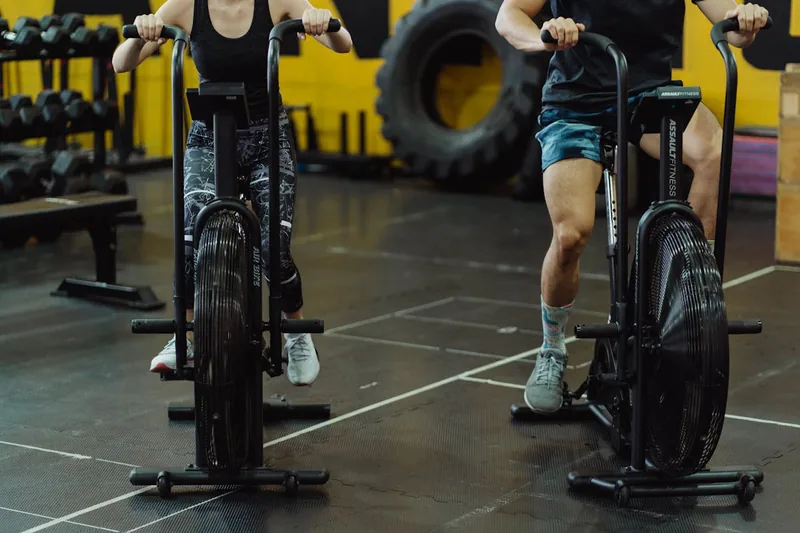Eine Person trainiert intensiv auf einem Air Bike, um Muskeln aufzubauen und zu definieren.