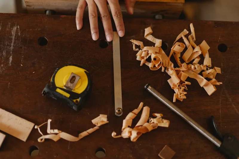 Fertig zugeschnittenes Holzwerkstück auf einer Werkbank, umgeben von Werkzeugen.