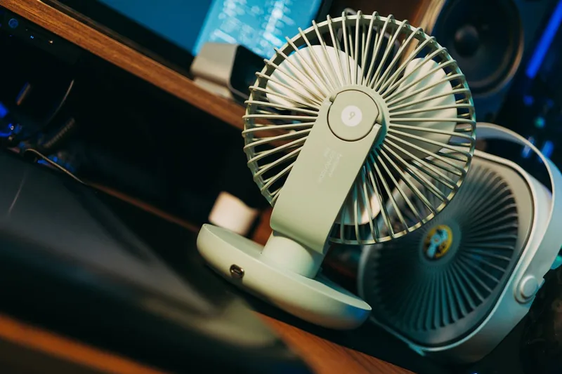 Ein moderner, kompakter Akku-Ventilator in hellem Design, freigestellt auf weißem Hintergrund, bereit für den Einsatz.
