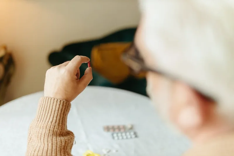 Eine Hand, die eine Algenöl-Kapsel zur Einnahme hält.