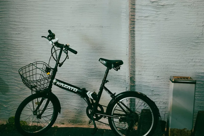 Eine Person fährt mit einem stilvollen Alu Klapprad durch eine moderne Stadtlandschaft.