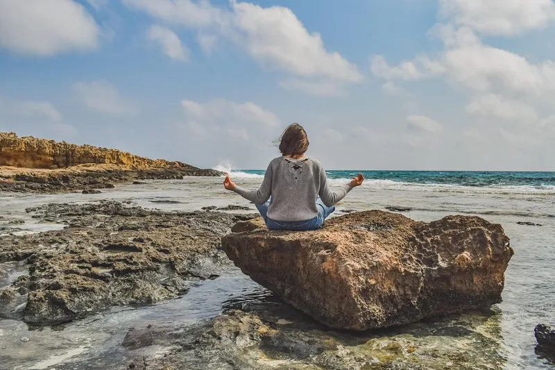Person meditiert in ruhiger Umgebung, symbolisiert Wellness und Stressabbau durch Ashwagandha.