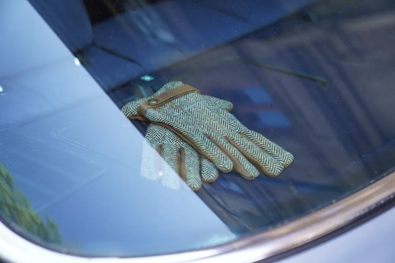 Ein Paar elegante, braune Leder-Autofahrer-Handschuhe als hochwertiges Produkt präsentiert.