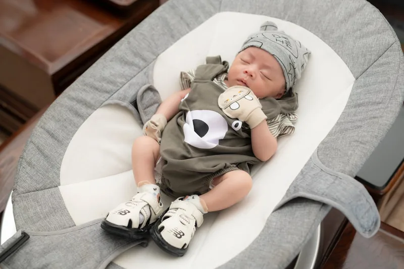 Ein fröhliches Baby genießt sanfte Schaukelbewegungen in einer automatischen Babyschaukel.