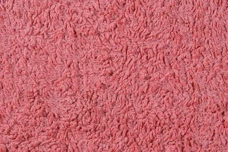 Nahaufnahme des weichen, saugfähigen Frottee-Stoffs eines Bademantels, der die Materialqualität zeigt.