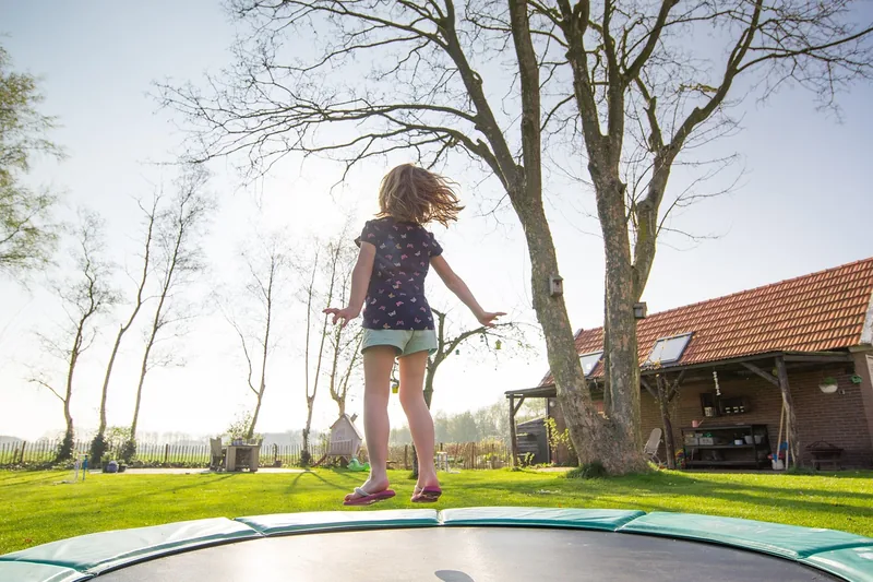 Lachende Kinder rennen und spielen auf einem Spielplatz, symbolisierend gesunde Fußentwicklung und Aktivität.