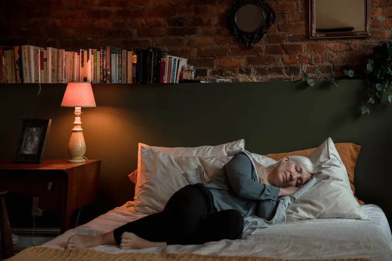 Ein gemütliches Schlafzimmer mit einem Bauchschläferkissen auf einem frisch bezogenen Bett, einladend für erholsamen Schlaf.