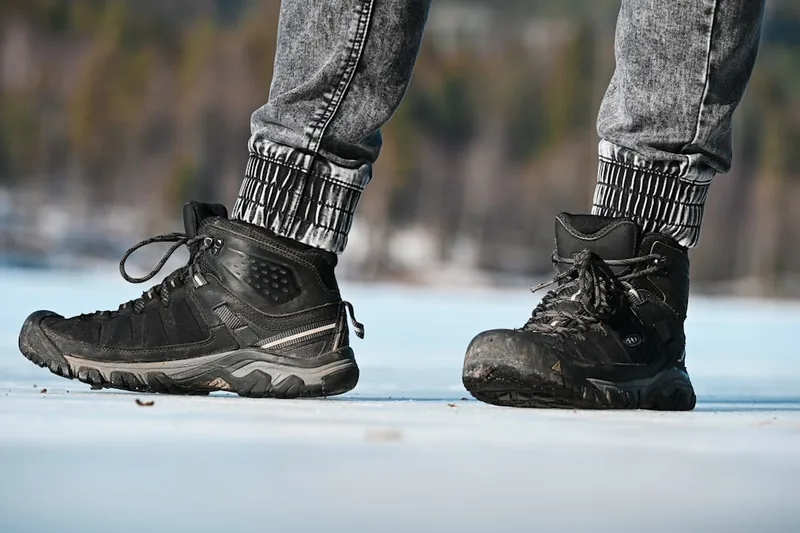 Eine Person trägt beheizbare Socken unter Wanderstiefeln im Winter, genießt Outdoor-Komfort.