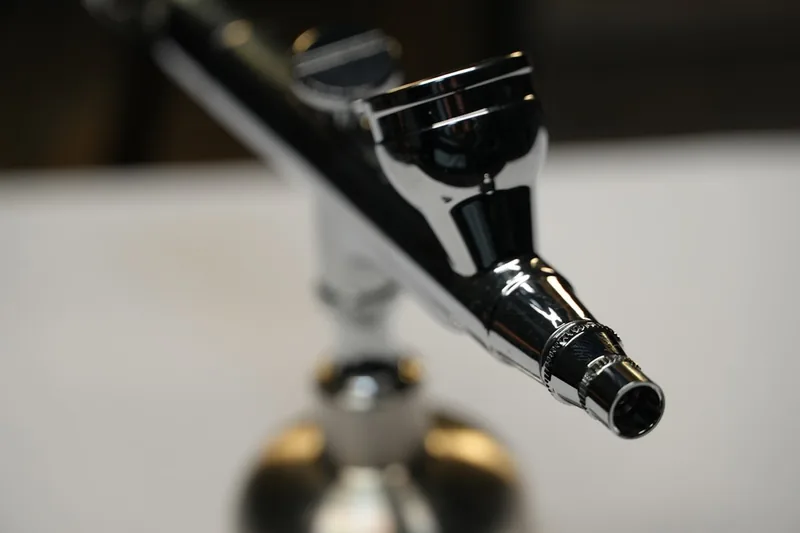 Professionelle Airbrushpistole auf hellem Hintergrund, bereit für kreative Projekte in Kunst und Modellbau.