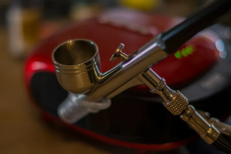 Nahaufnahme der feinen Düse einer Airbrushpistole, die präzise Verarbeitung und hohe Qualität zeigt.