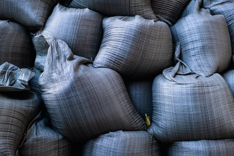 Nahaufnahme der strapazierfähigen, gewebten Polypropylen-Textur eines Big-Bag-Sacks mit Nähten.