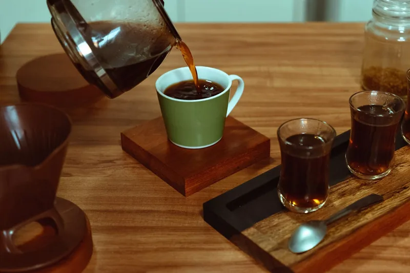 Eine dampfende Tasse frischen Filterkaffees auf einer hellen Küchentheke mit leichter Morgenstimmung.