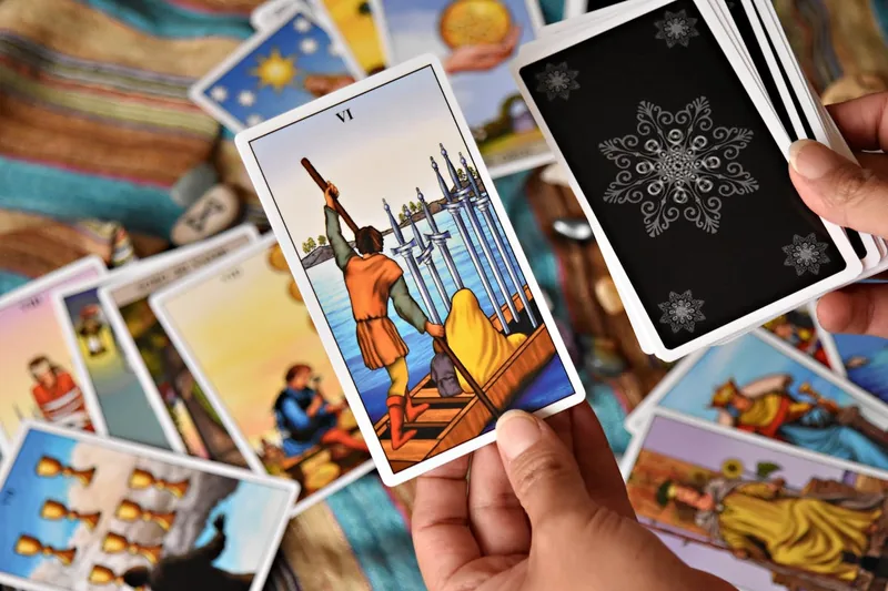 Eine Hand legt luxuriöse Tarotkarten mit Goldfolie.