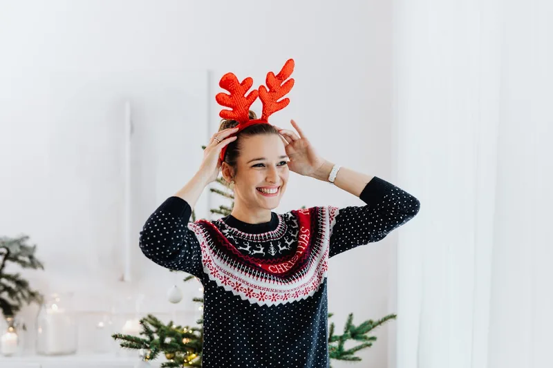 Ein detailreicher Weihnachtspullover für Damen, festlich und gemütlich auf neutralem Hintergrund präsentiert.