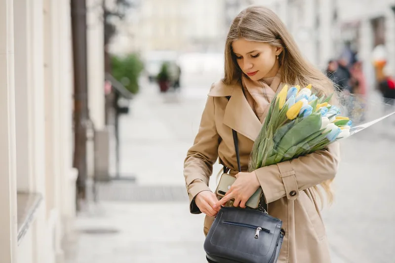 Eine Frau trägt ihre moderne Beuteltasche lässig über der Schulter beim Spaziergang in der Stadt.