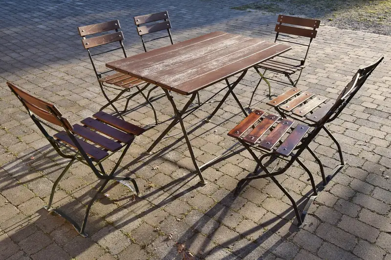 Eine Person klappt eine Bierzeltgarnitur-Bank auf, ideal für Kinder und Erwachsene Vergleich.
