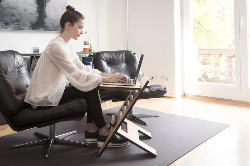 Eine Person sitzt auf einem Bürostuhl, der über eine Bodenschutzmatte auf einem Teppich rollt.