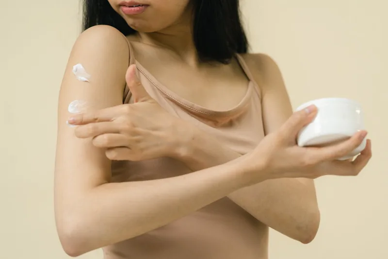 Eine Person trägt Bodylotion sanft auf ihren Arm auf, für eine tägliche Hautpflege.