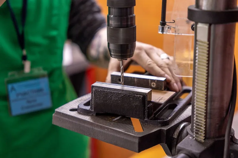 Eine Hand montiert ein Bohrfutter MK2 an einer Tischbohrmaschine für präzise Bohrungen.