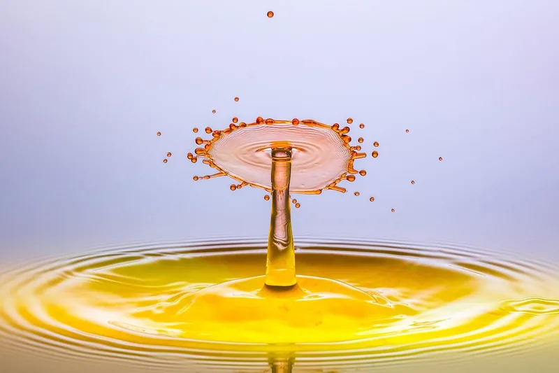 Nahaufnahme von klarer Bremsflüssigkeit, die aus einer Flasche gegossen wird, feine Struktur.