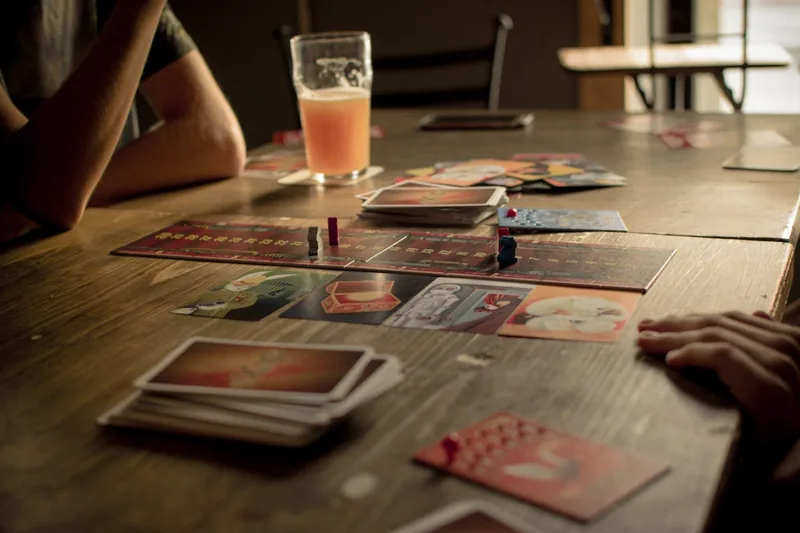 Freunde haben einen gemütlichen Brettspielabend mit Snacks und Getränken in entspannter Atmosphäre.
