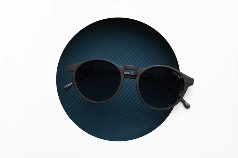 Eine moderne polarisierte Sonnenbrille mit dunklen Gläsern, im Studiolicht vor neutralem Hintergrund dargestellt.