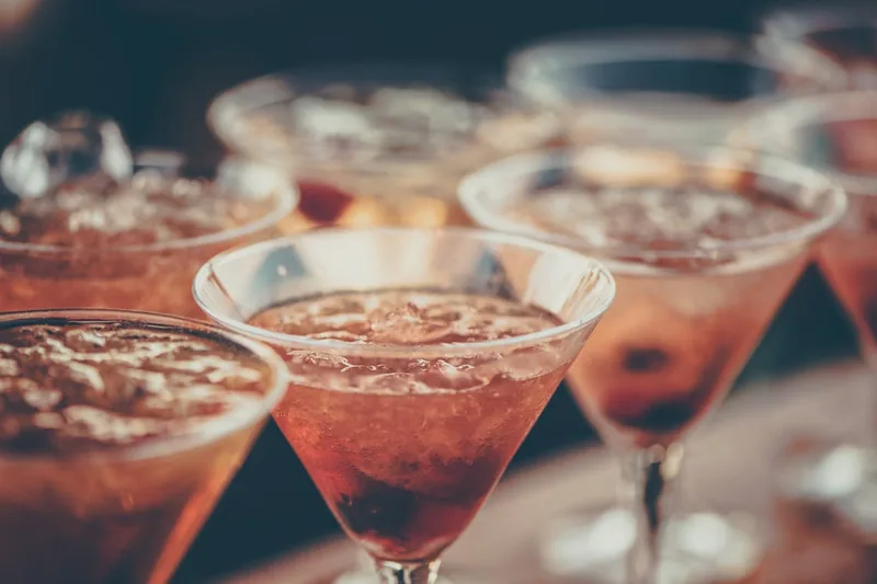 Elegante Homebar-Szene mit mehreren Cocktailgläsern und passendem Ambiente, symbolisiert stilvollen Genuss.