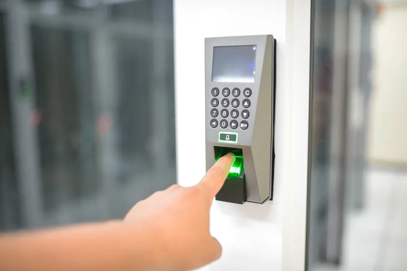 Eine Person gibt einen PIN-Code an einem elektronischen Codeschloss an einer Haustür ein.