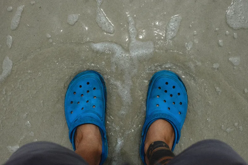 Komfortschuhe am Strand im Sand liegend, perfekt für einen entspannten Sommertag am Meer.