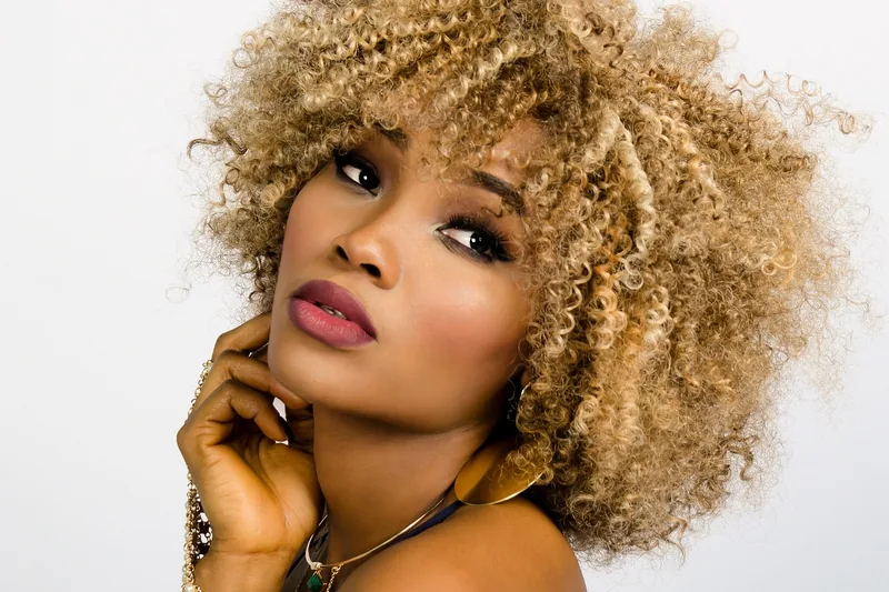 Eine Frau mit perfekt gestylten, voluminösen Locken, die mit einem Curler erzielt wurden.