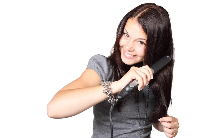 Ein modernes Dampfglätteisen im Vordergrund, bereit für seidig glattes Haar und professionelles Styling.