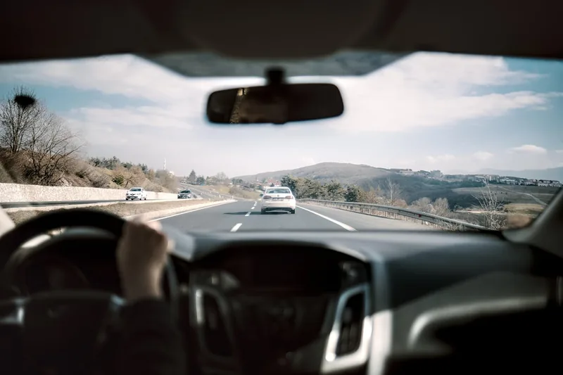 Eine Hand montiert eine 4K Dashcam an der Windschutzscheibe eines Autos. Einfache Installation.