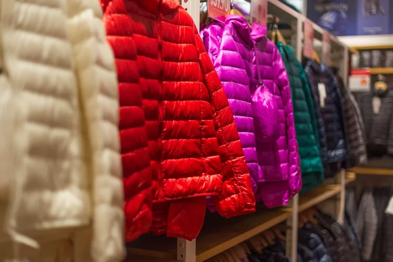 Eine hochwertige Daunenjacke in schlichtem Design, sauber auf einem Kleiderbügel präsentiert, Fokus auf Qualität.