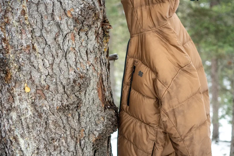Nahaufnahme des gesteppten Materials einer Herren Daunenjacke, die Daunenfüllung und Nähte zeigend.