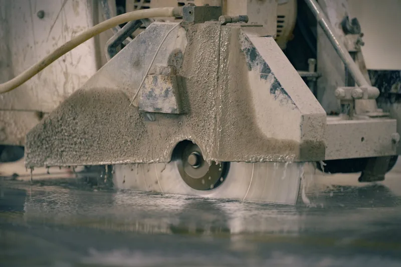 Eine Baustelle mit geschnittenen Steinplatten und Staub in der Luft, das Ergebnis effizienter Trennscheibenarbeit.
