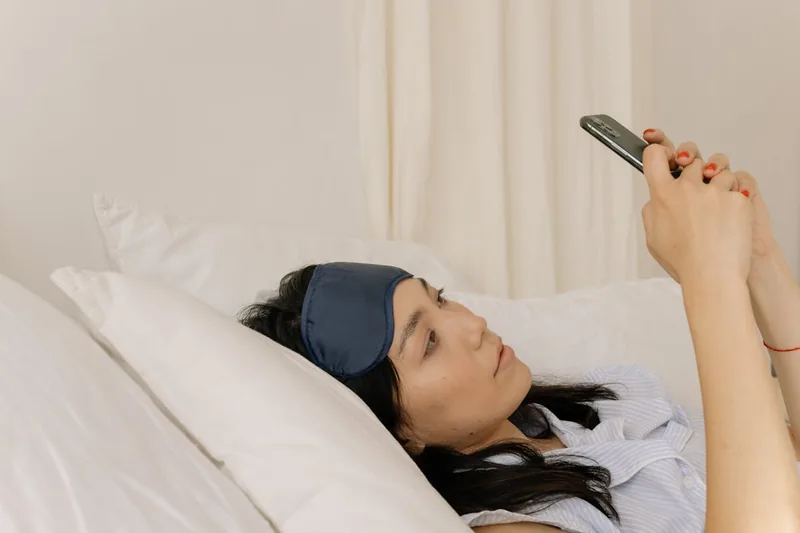Eine Person nutzt ein Dinkelkissen zur Unterstützung des Nackens im Bett, für einen erholsamen Schlaf und zur Kaufberatung.