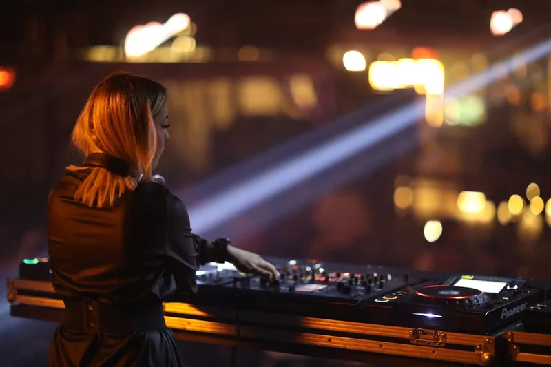 Ein DJ-Pult in einer lebhaften Club-Umgebung, das die perfekte Bühne für einen Hochleistungs-DJ-Mixer bietet.